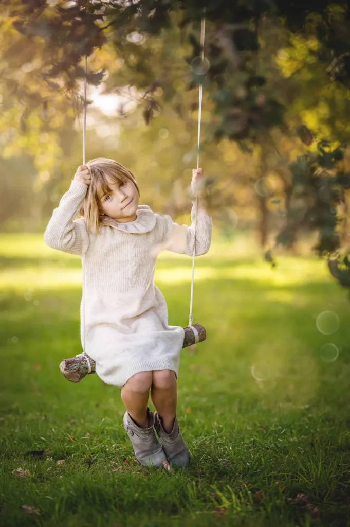 Petite Fille jouant à la balançoire dans les arbres.