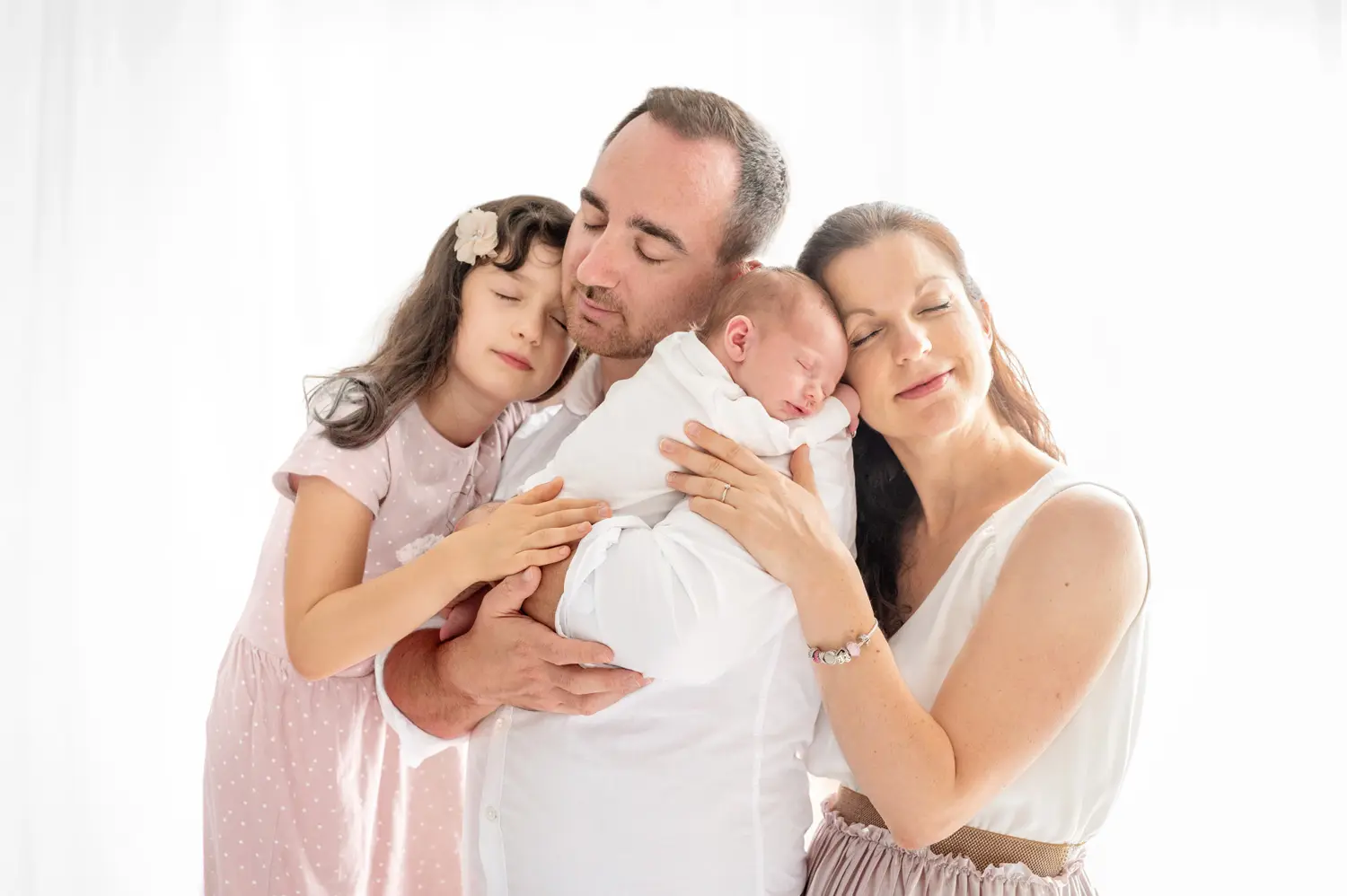 Photos famille à Nantes, parents qui s'enlace avec leurs enfants dans le salon