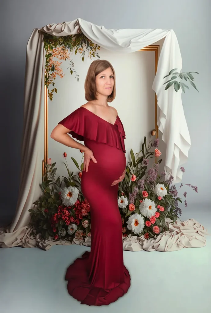 Femme enceinte dans une longue robe devant une arche de fleur et de draps blanc