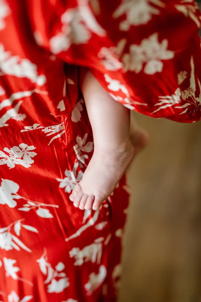 Plan sur les jambes de bébé autour de sa mère.