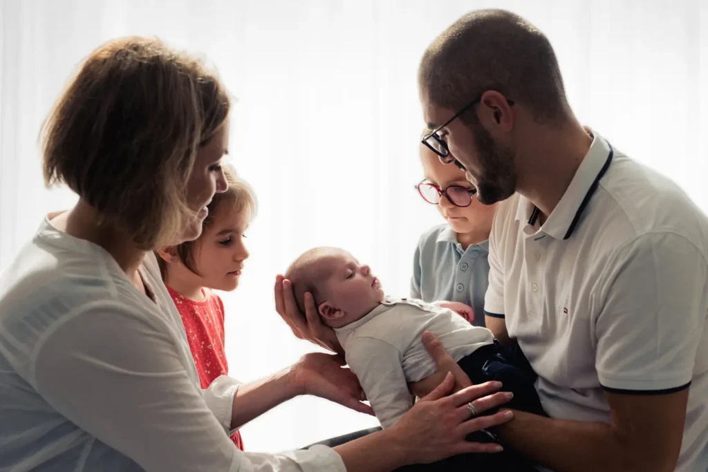 Famille prenant le bébé dans leurs bras.