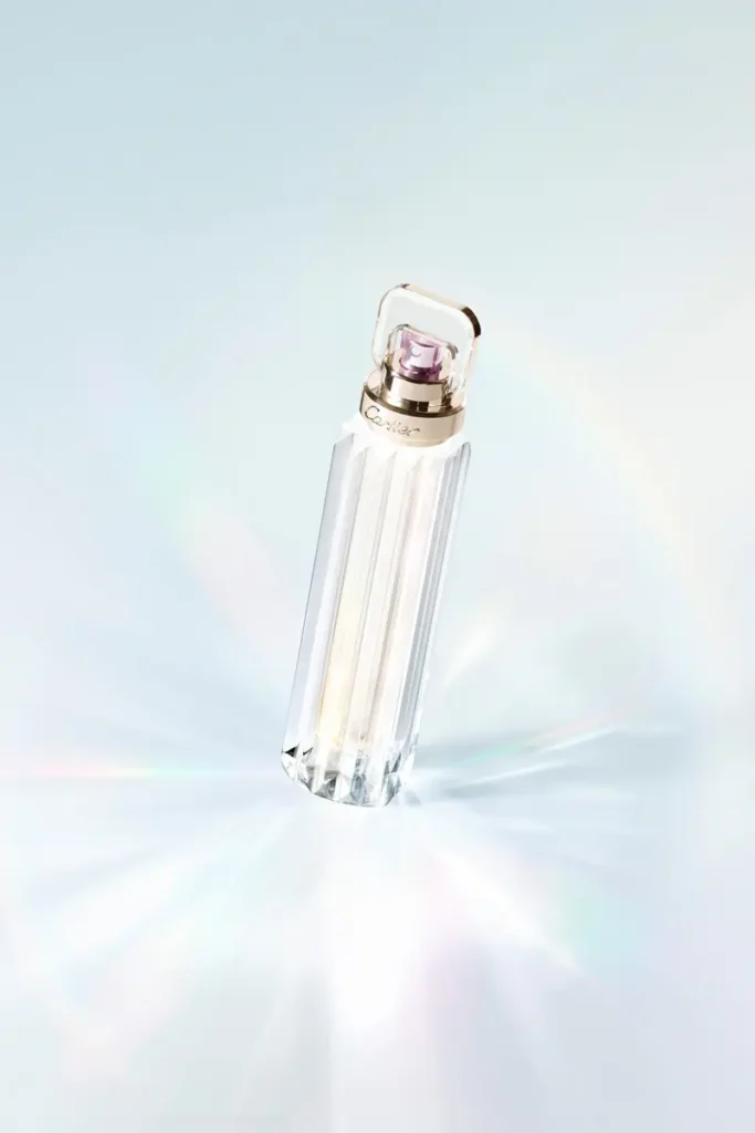 Flacon de parfum avec reflet lumineux sur un fond bleuté.