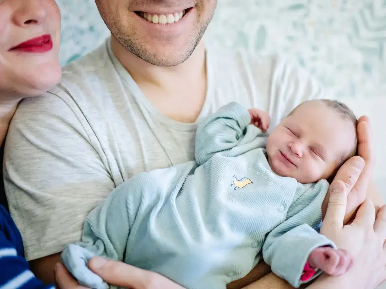 Plan sur bébé qui est dans les bras de ses parents